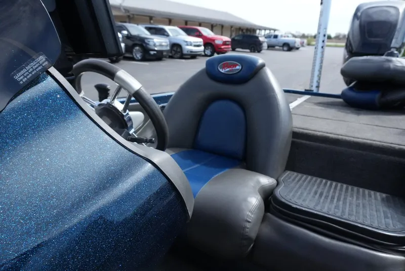 Slide: The Image of 2005 Ranger Z20 boat interior with blue and gray seating, steering wheel, and dashboard. - 14