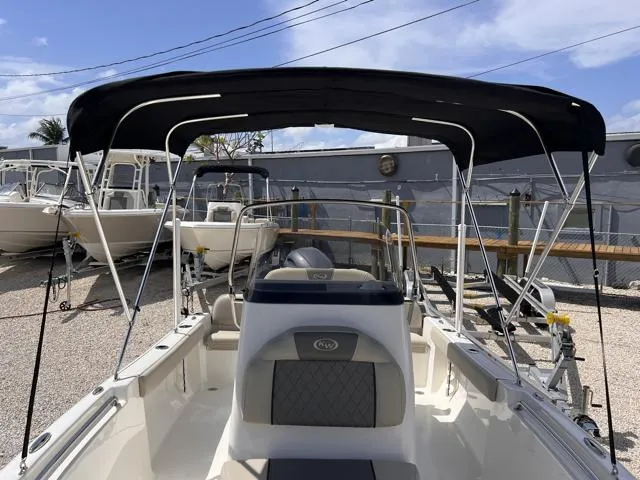 Slide: The Image of 2025 Key West 189 FS boat with black canopy in a marina setting. - 10