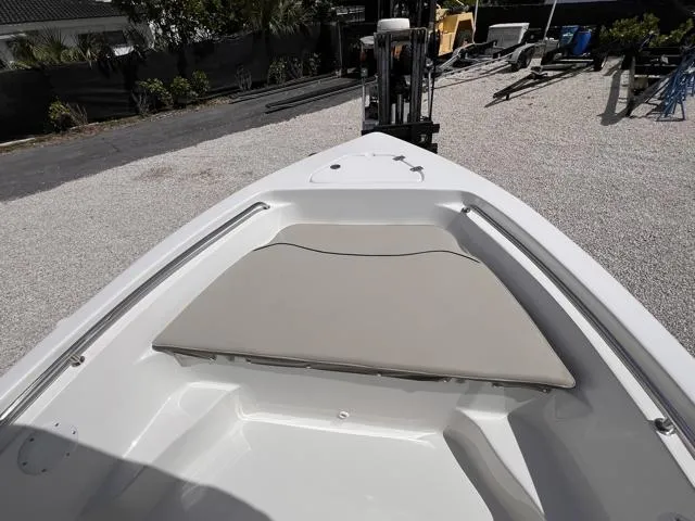 Slide: The Image of 2025 Key West 189 FS boat bow with cushioned seating, parked on gravel. - 22