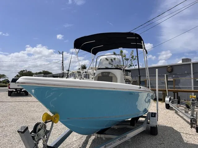 Slide: The Image of 2025 Key West 189 FS boat with canopy on trailer, parked outdoors under blue sky. - 4