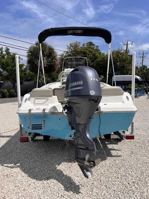 Slide: The Image of 2025 Key West 189 FS boat with Yamaha 115 engine, parked on gravel. - 6