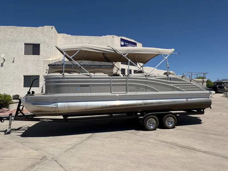 Slide: The Image of 2013 Bennington 2575 RCW IO pontoon boat on trailer, parked outdoors. - 0