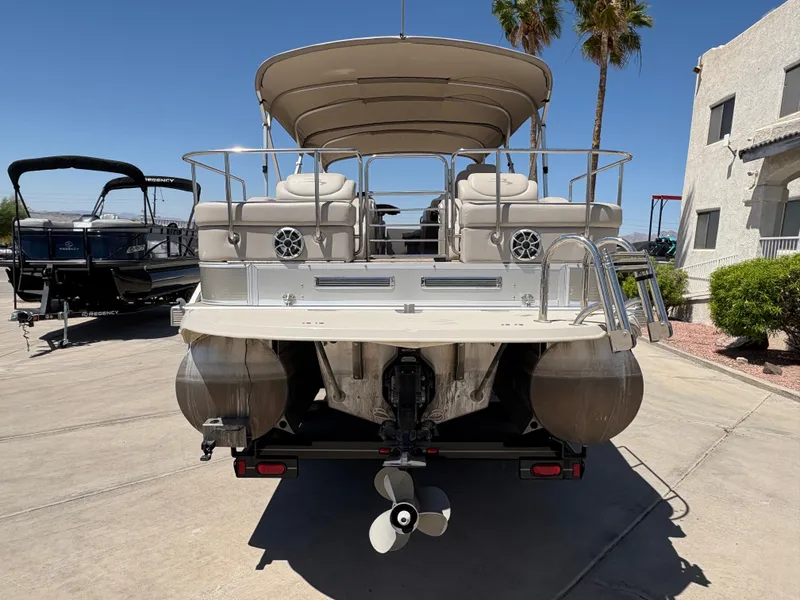 Slide: The Image of 2013 Bennington 2575 RCW IO pontoon boat, rear view, parked on concrete, sunny day. - 3