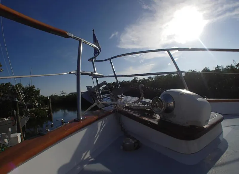 Slide: The Image of 1987 Tayana 45 Expedition Trawler deck with railing, under a bright sunlit sky. - 9