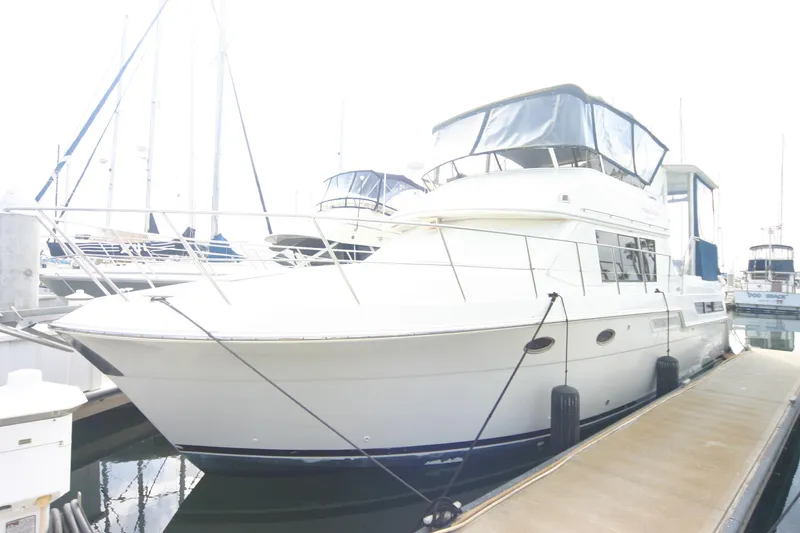 The Image of 1997 Carver 405 yacht docked at marina, featuring sleek design and spacious upper deck. - 1