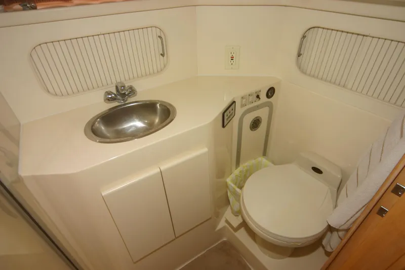 Slide: The Image of 1997 Carver 405 yacht bathroom with sink, toilet, and storage cabinets. - 8