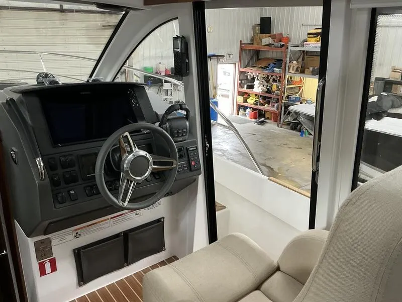 Slide: The Image of Interior of 2025 Nimbus 365 Coupe boat with steering wheel and dashboard in a workshop. - 16