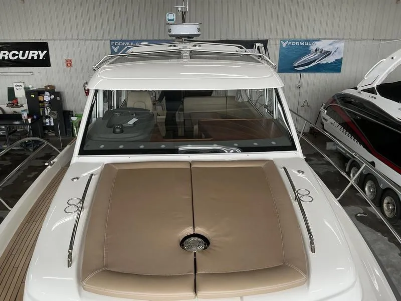 Slide: The Image of 2025 Nimbus 365 Coupe boat with beige sunpad, docked indoors. - 19