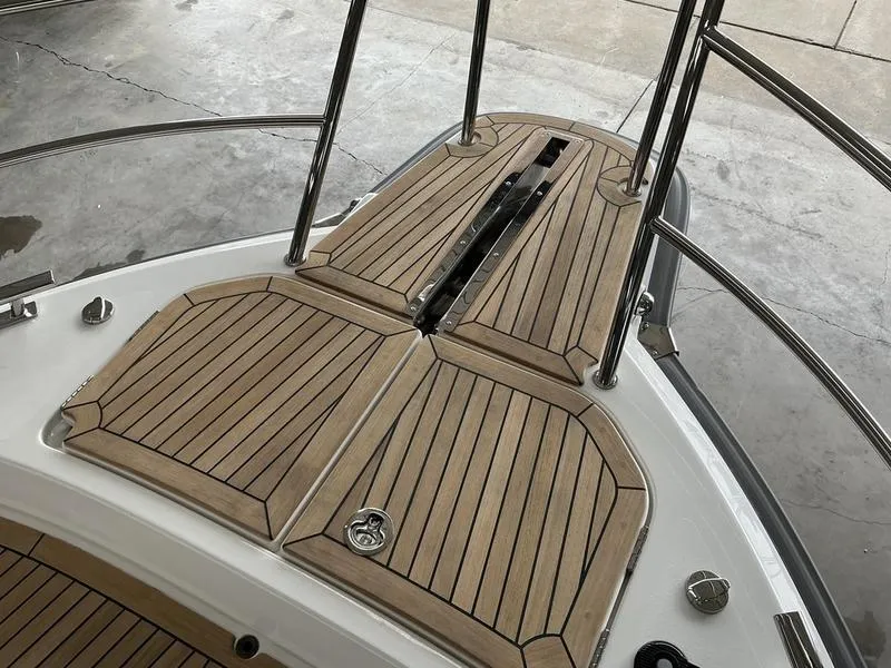 Slide: The Image of 2025 Nimbus 365 Coupe boat deck with teak flooring and stainless steel railings. - 21