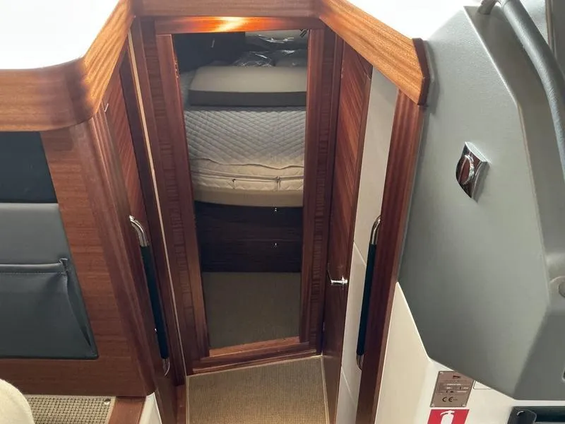 Slide: The Image of Interior cabin view of 2025 Nimbus 365 Coupe, featuring wooden finishes and cozy bedding. - 27