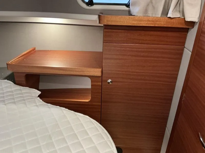 Slide: The Image of Interior of 2025 Nimbus 365 Coupe, featuring wooden cabinetry and a quilted bed. - 32