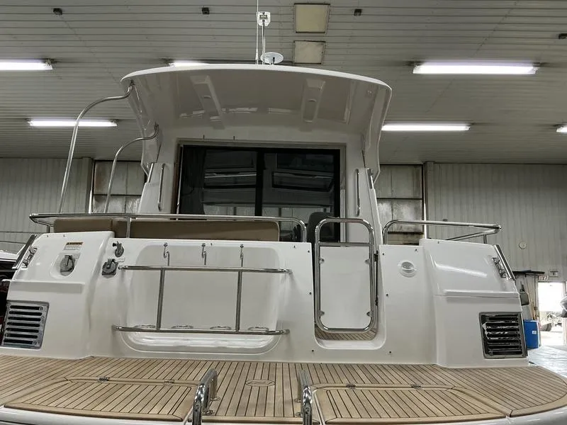 Slide: The Image of 2025 Nimbus 365 Coupe yacht in a well-lit indoor setting, showcasing its rear deck. - 5