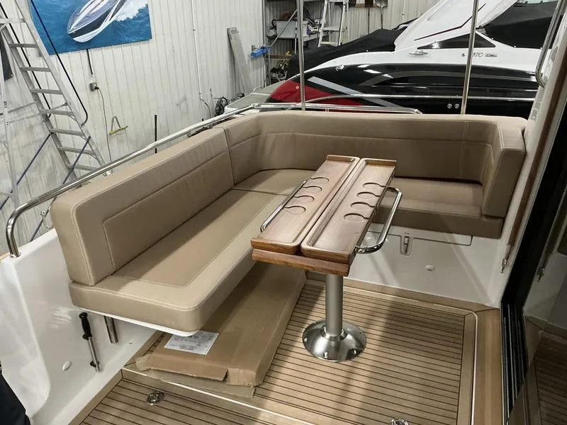 Slide: The Image of Luxurious seating area on a 2025 Nimbus 365 Coupe yacht with wooden table and cushions. - 6