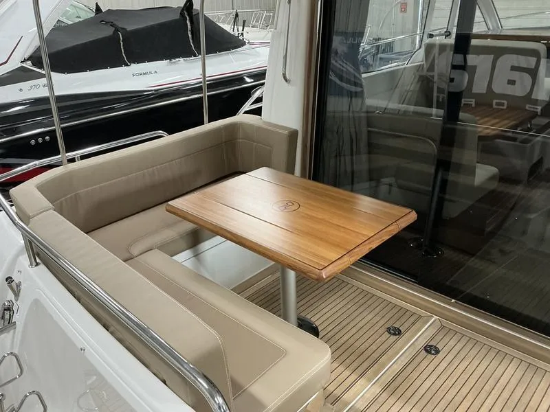 Slide: The Image of Interior of 2025 Nimbus 365 Coupe with wooden table and cushioned seating. - 7