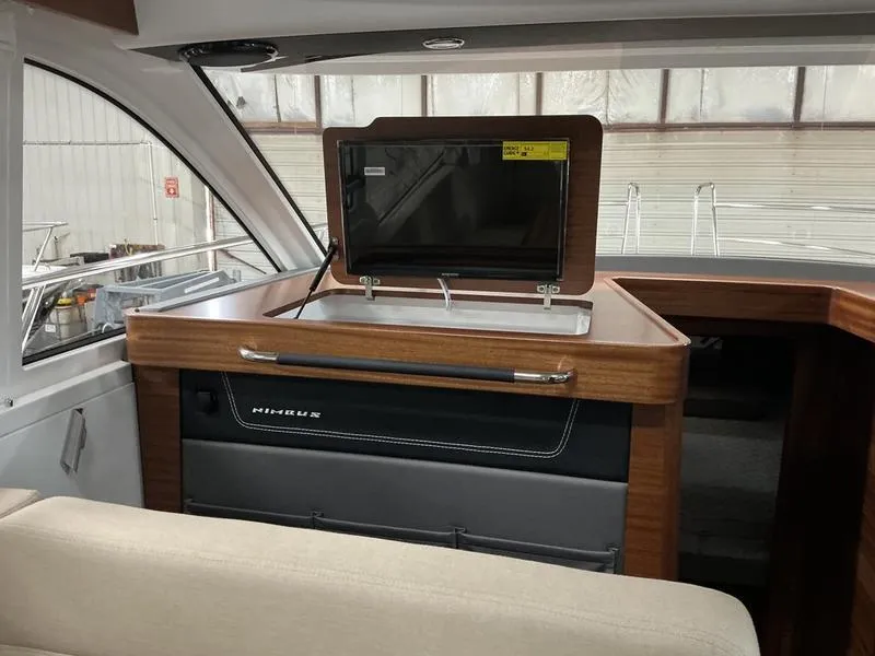 Slide: The Image of Interior of 2025 Nimbus 365 Coupe featuring a sleek wooden cabinet and modern TV screen. - 9