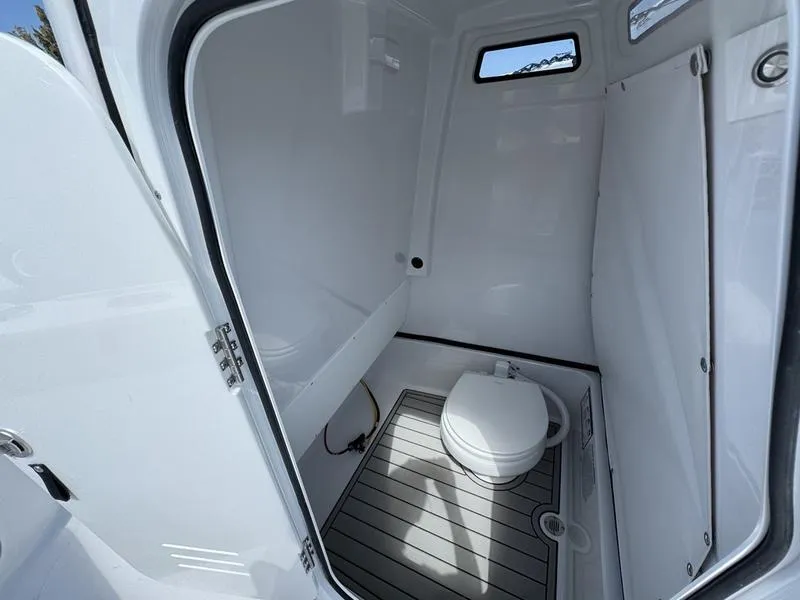 Slide: The Image of 2025 Sportsman Masters 267 boat interior bathroom with toilet and window. - 14