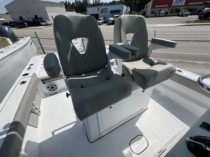 Slide: The Image of 2025 Sportsman Masters 267 boat seats, gray upholstery, armrests, outdoor setting. - 17