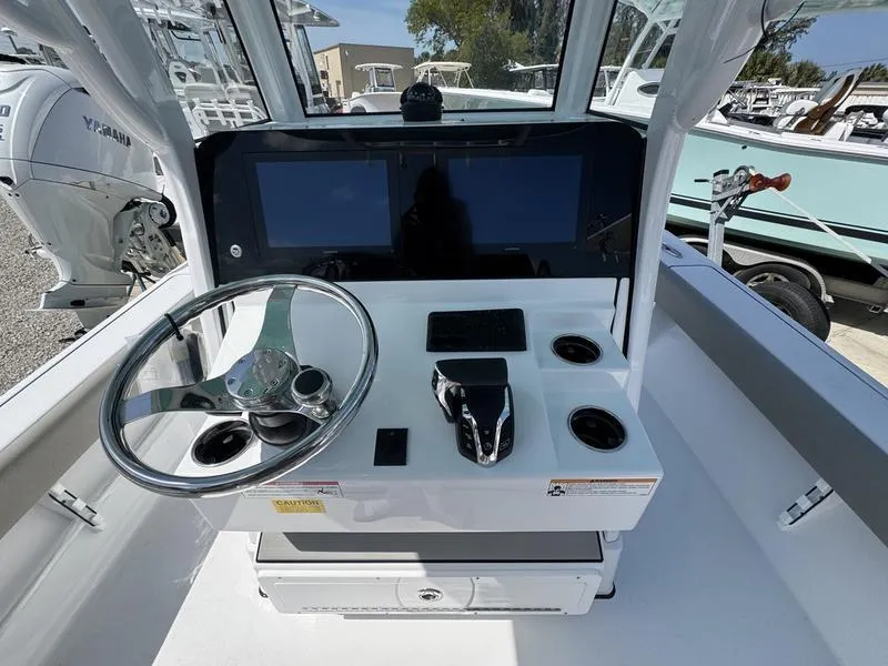 Slide: The Image of 2025 Sportsman Masters 267 boat console with steering wheel, dual screens, and controls. - 18