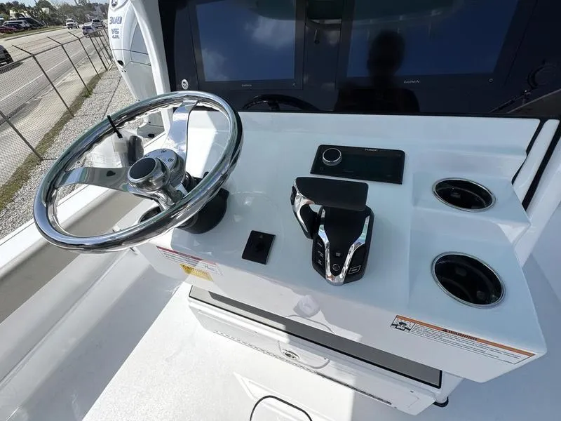 Slide: The Image of Control panel of 2025 Sportsman Masters 267 boat with steering wheel and throttle. - 19