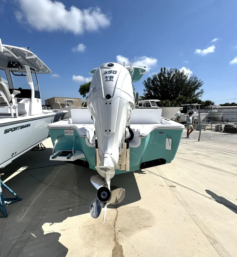 Slide: The Image of 2025 Sportsman Masters 267 boat with powerful outboard motor, parked outdoors under a clear blue sky. - 3