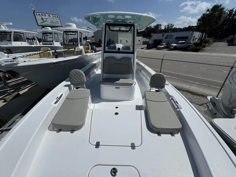 Slide: The Image of 2025 Sportsman Masters 267 boat with cushioned seating, displayed outdoors at a dealership. - 5