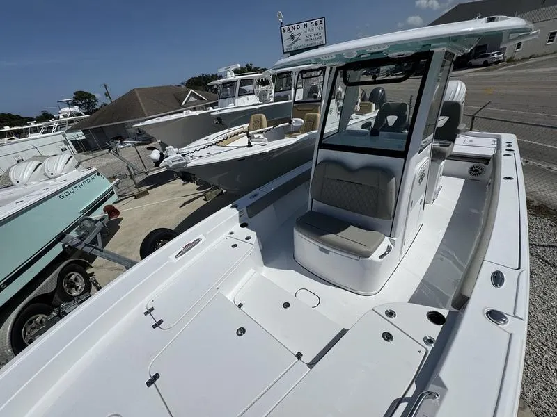 Slide: The Image of 2025 Sportsman Masters 267 boat with spacious deck and seating, displayed at a marina. - 9