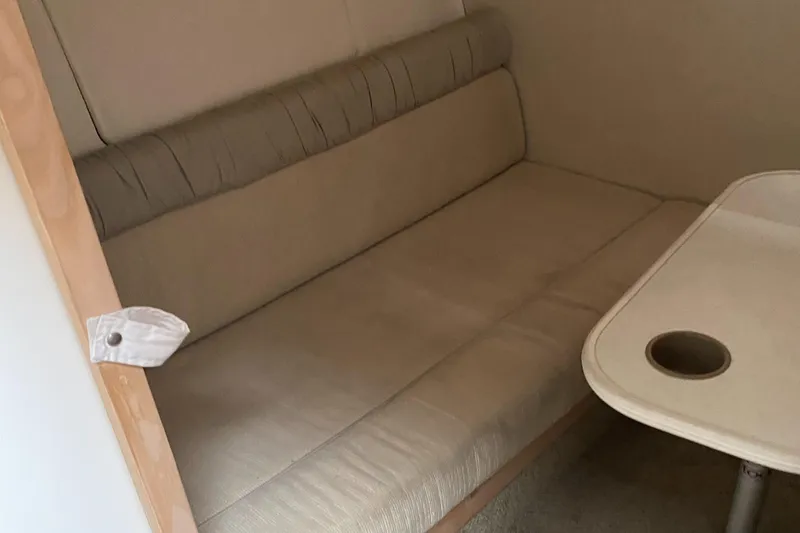 Slide: The Image of Interior seating area of a 2000 Maxim Yachts 3300SCR with beige cushions and a table. - 17