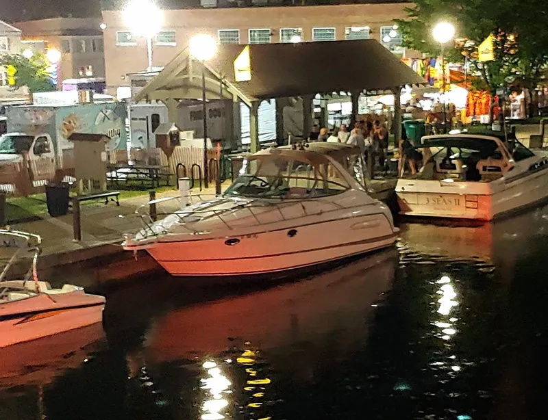 Slide: The Image of 2000 Maxim Yachts 3300SCR docked at a lively waterfront at night. - 7