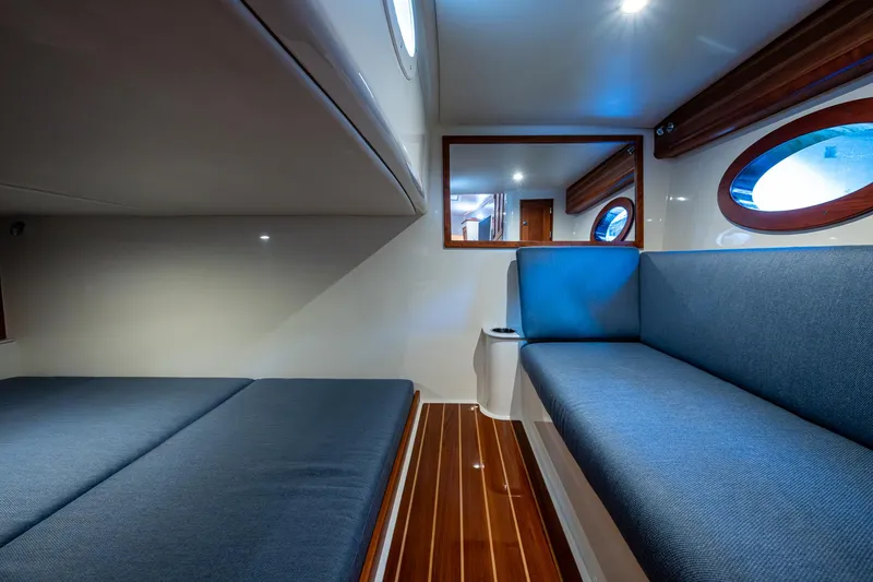 Slide: The Image of Interior of 2021 Hinckley Sport Boat 40 X with blue seating and wooden flooring. - 23