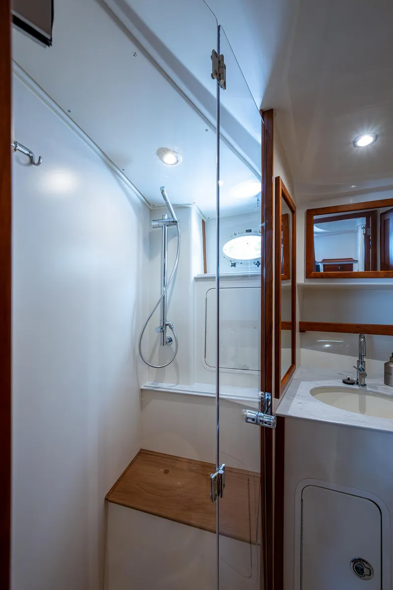 Slide: The Image of 2021 Hinckley Sport Boat 40 X bathroom with shower, wooden accents, and modern fixtures. - 27