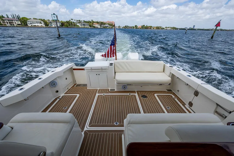Slide: The Image of Hinckley Sport Boat 40 X 2021 cruising on water, featuring spacious deck and seating. - 6