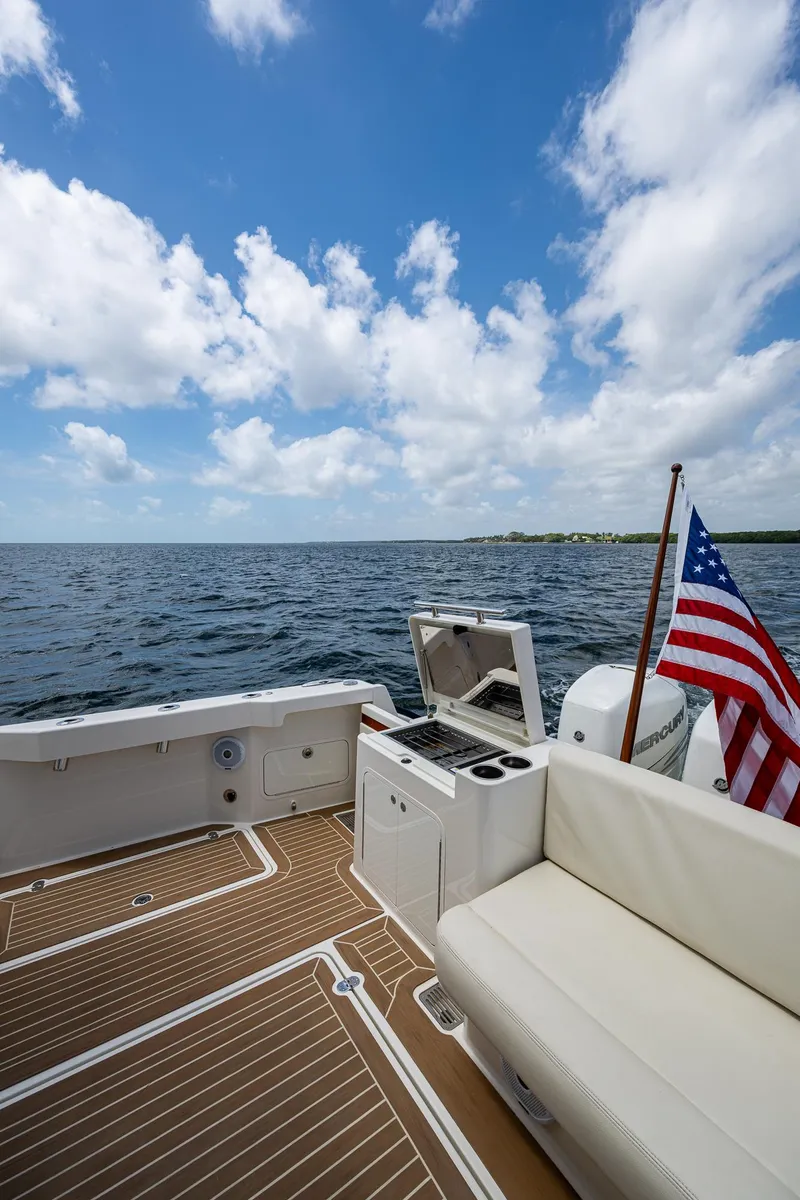 Slide: The Image of Hinckley Sport Boat 40 X, 2021 model, with American flag, on open water under blue sky. - 7