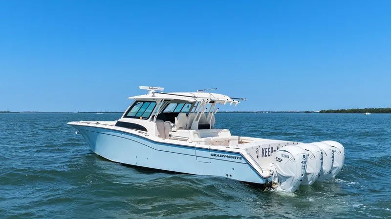 Slide: The Image of 2023 Grady-White Canyon 456 boat cruising on open water under clear blue sky. - 10