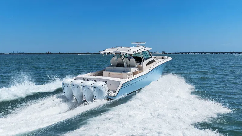 Slide: The Image of 2023 Grady-White Canyon 456 boat cruising on open water, showcasing powerful engines. - 14