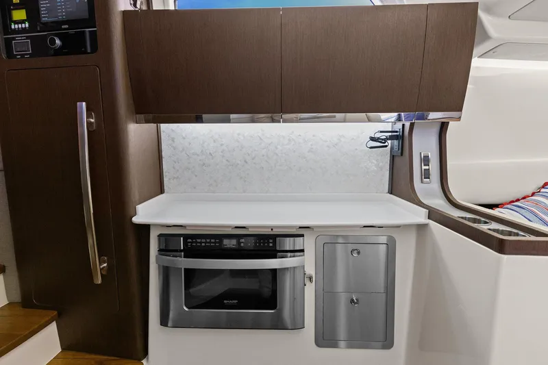 Slide: The Image of 2023 Grady-White Canyon 456 interior kitchen with microwave and storage cabinets. - 24