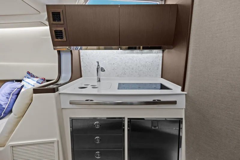 Slide: The Image of 2023 Grady-White Canyon 456 interior kitchenette with modern cabinetry and sleek design. - 25