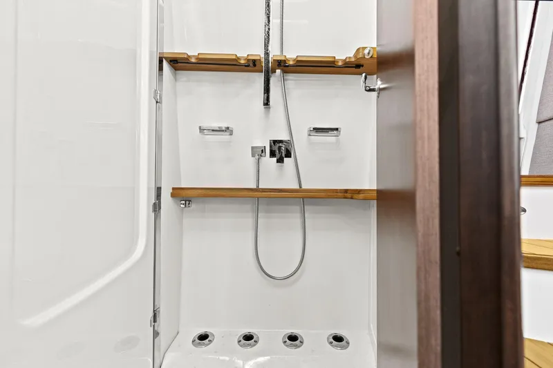 Slide: The Image of 2023 Grady-White Canyon 456 shower with modern fixtures and wooden accents. - 29