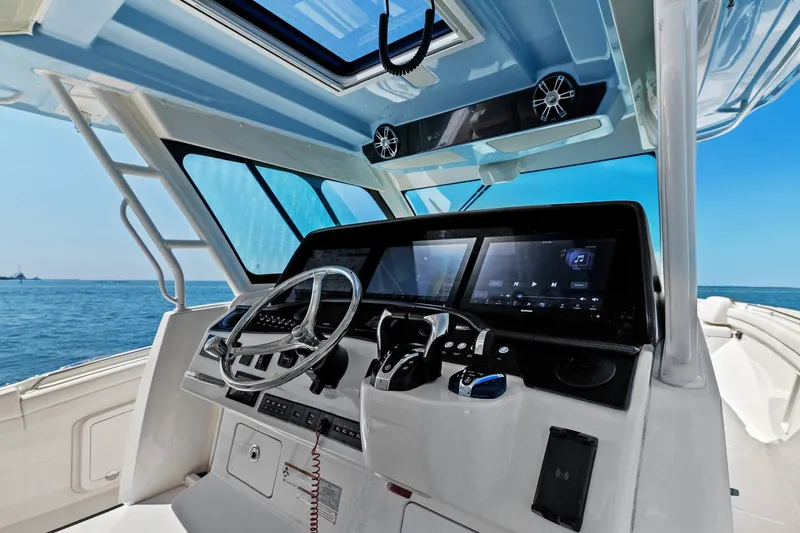 Slide: The Image of 2023 Grady-White Canyon 456 helm with modern controls and ocean view. - 3