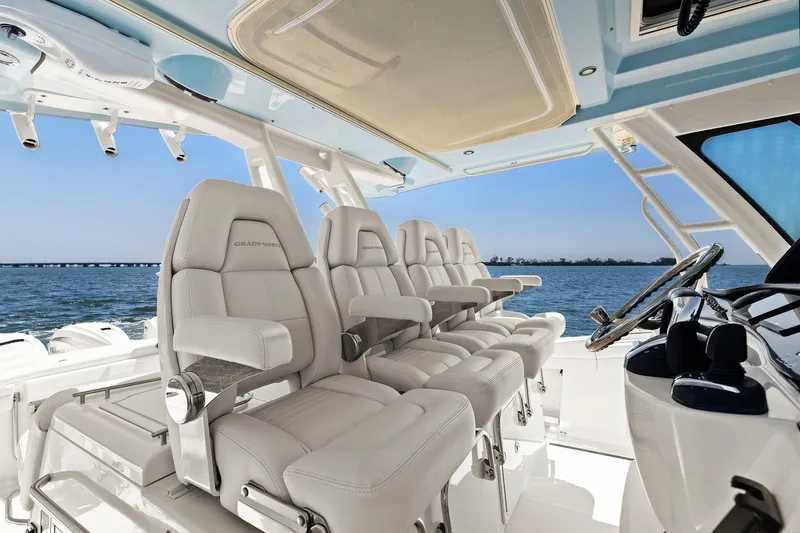 Slide: The Image of 2023 Grady-White Canyon 456 boat interior with luxurious seating and helm, overlooking the ocean. - 38