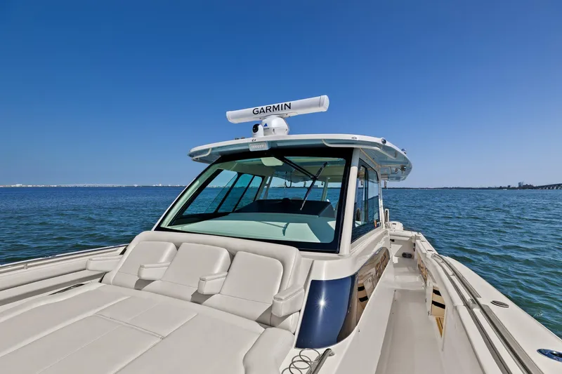 Slide: The Image of 2023 Grady-White Canyon 456 boat on open water under clear blue sky. - 49