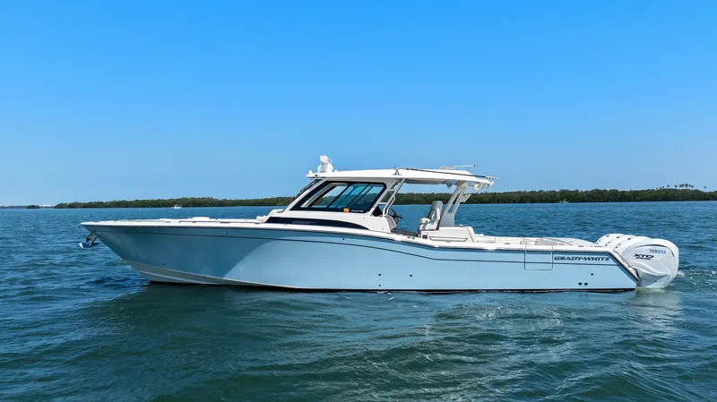 Slide: The Image of 2023 Grady-White Canyon 456 boat cruising on open water under clear blue sky. - 5