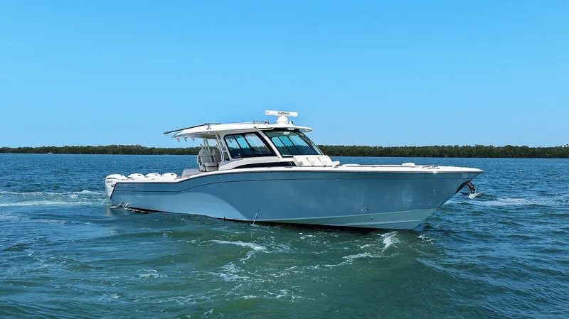 Slide: The Image of 2023 Grady-White Canyon 456 boat cruising on open water under clear blue sky. - 9