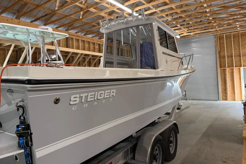 Slide: The Image of 2022 Steiger Craft 255 DV MIAMI boat in a wooden garage on a trailer. - 1