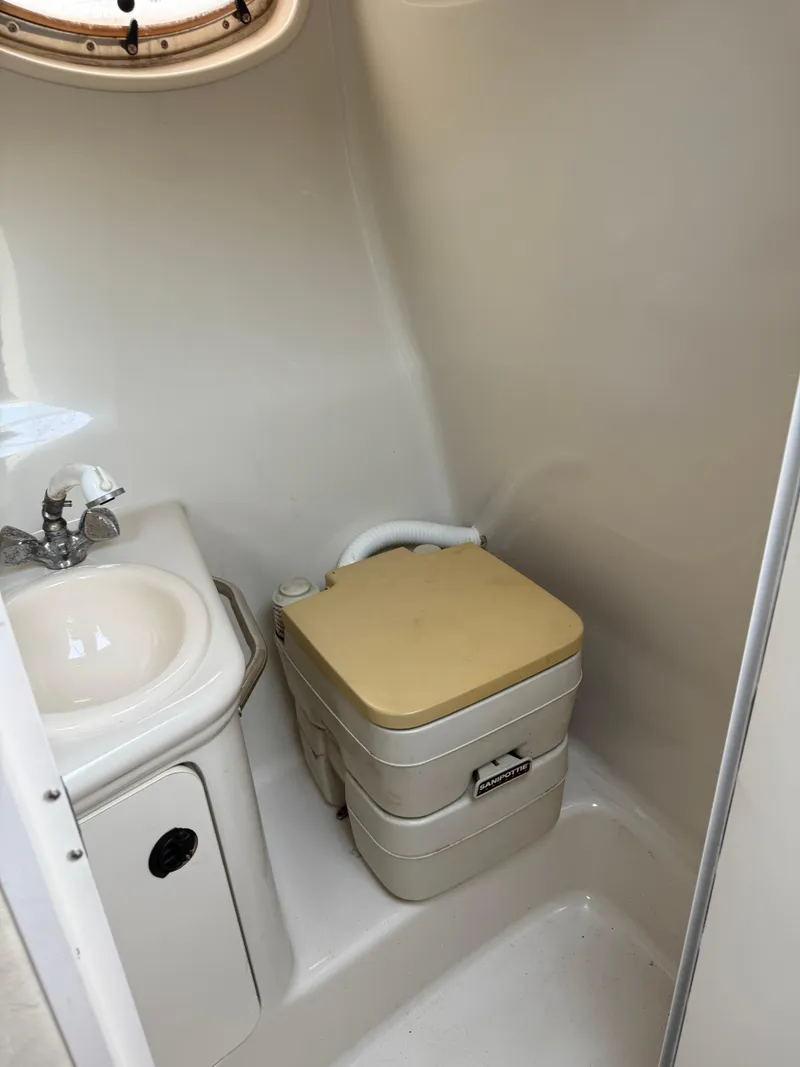 Slide: The Image of 2000 Sea Ray 240 Sundancer bathroom with sink and portable toilet. - 10