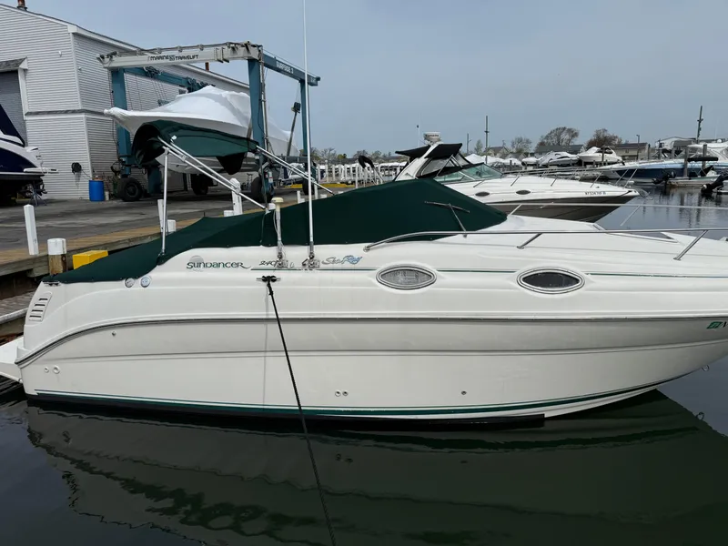Slide: The Image of 2000 Sea Ray 240 Sundancer docked at a marina, featuring a sleek white design. - 4