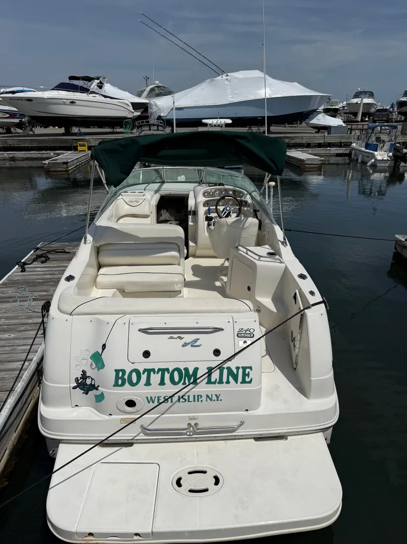 Slide: The Image of 2000 Sea Ray 240 Sundancer docked with green cover at marina. - 6