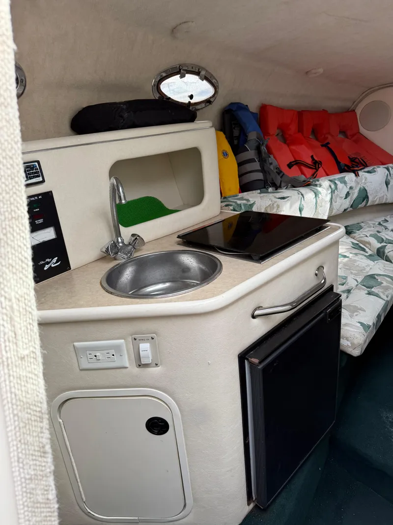 Slide: The Image of 2000 Sea Ray 240 Sundancer cabin with kitchenette, sink, and life jackets. - 8