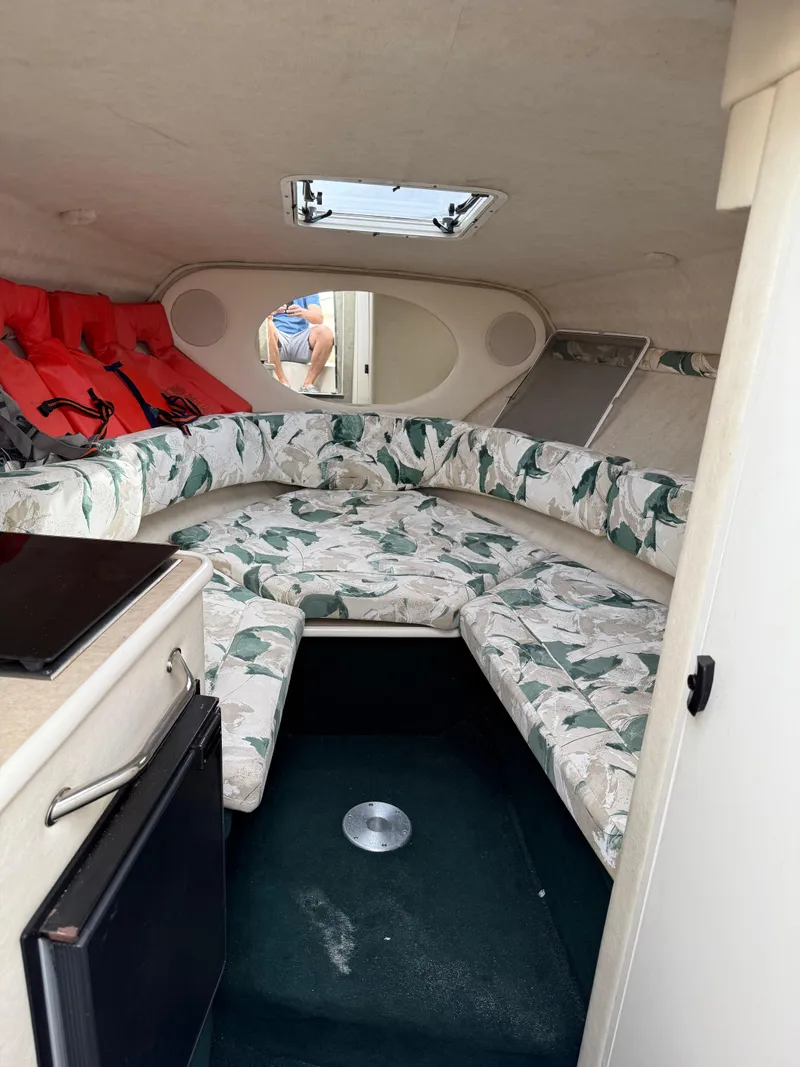 Slide: The Image of 2000 Sea Ray 240 Sundancer cabin interior with floral upholstery and life jackets. - 9