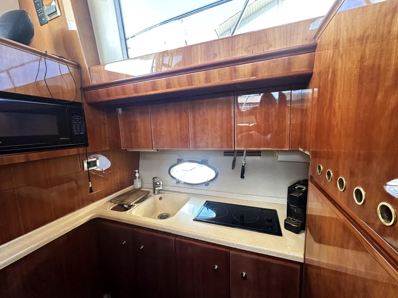 Slide: The Image of Luxurious kitchen interior of a 1996 Azimut 54 yacht with wood cabinetry and modern appliances. - 19