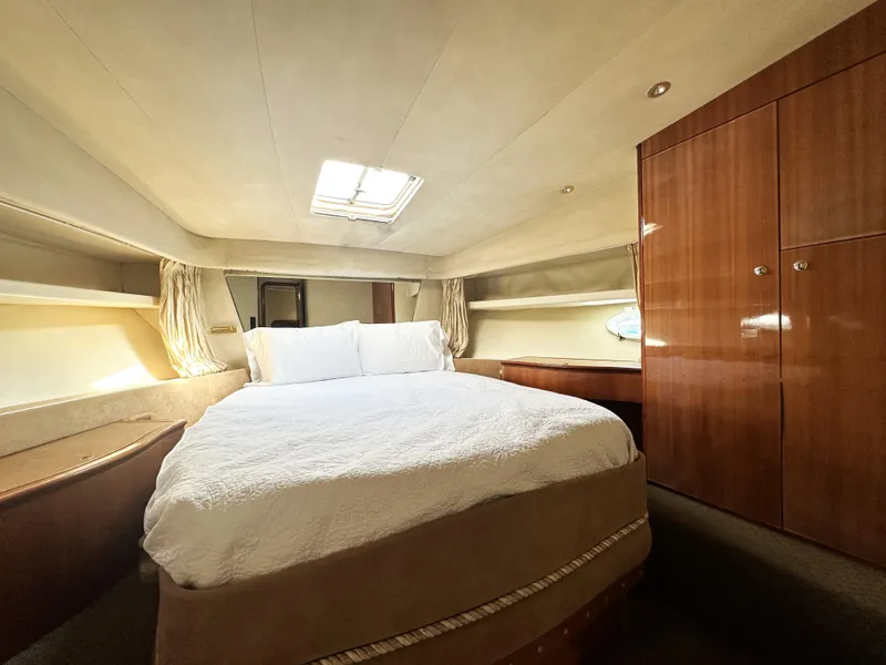 Slide: The Image of Luxurious bedroom interior of a 1996 Azimut 54 yacht with elegant wood finishes. - 26